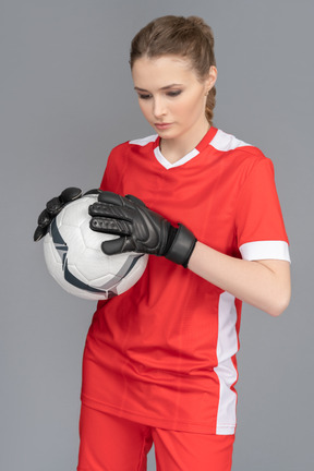 Женский вратарь держит мяч