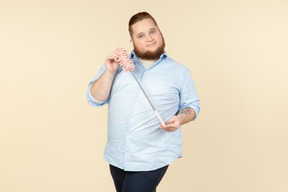 Young overweight househusband showing pipe-cleaner