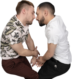 Flat lay of two young caucasian men lying on their sides touching foreheads