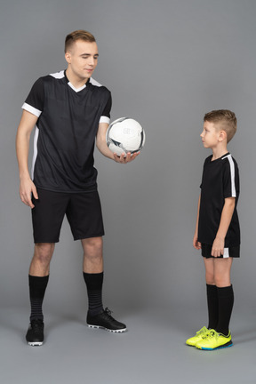 Full-length of a young man coaching little boy