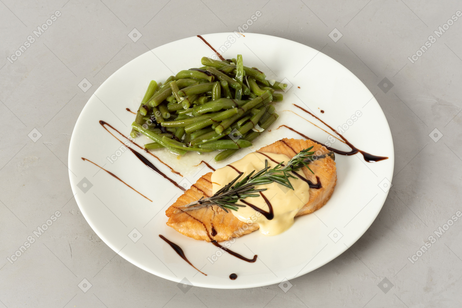 Dish of salmon with white sauce and string beans