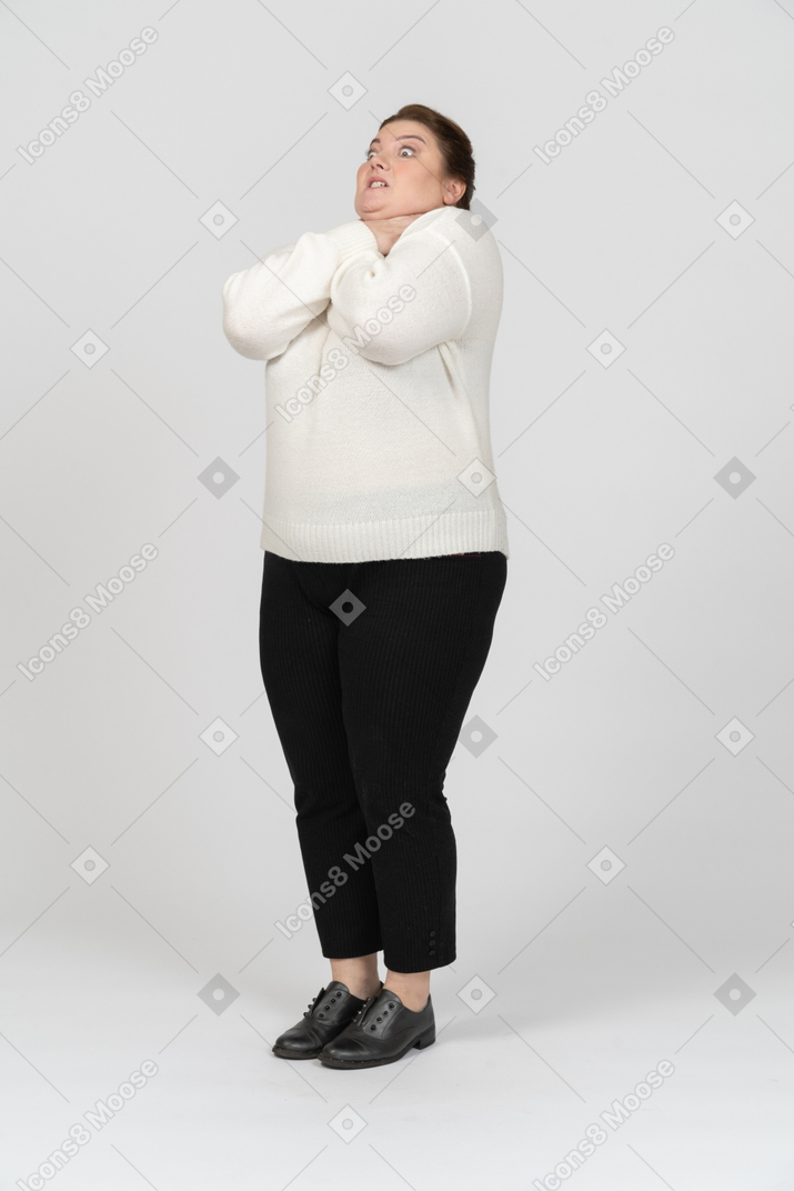 Front view of a plump woman in casual clothes chocking herself