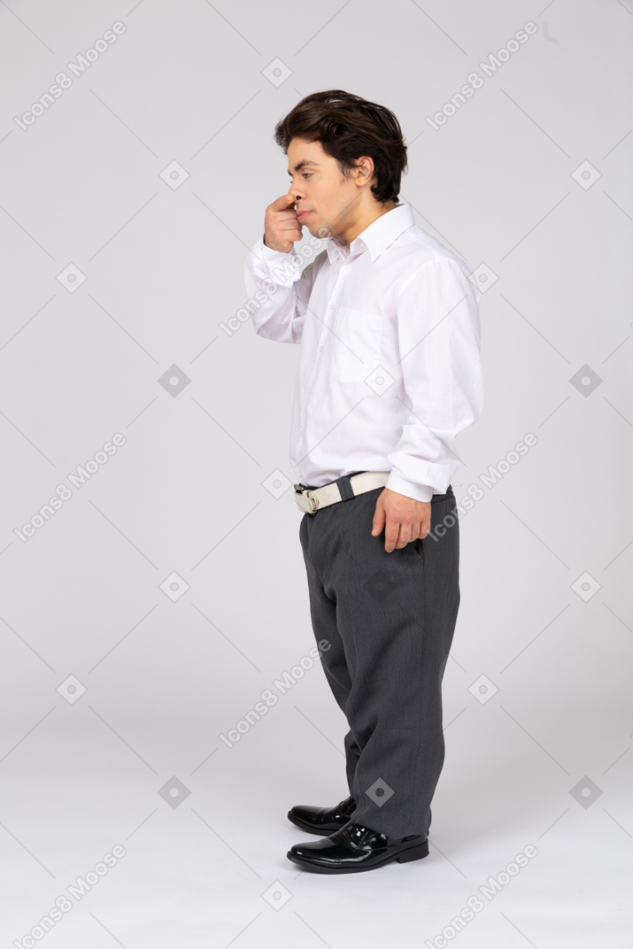 Young man pushing his nose up with his finger