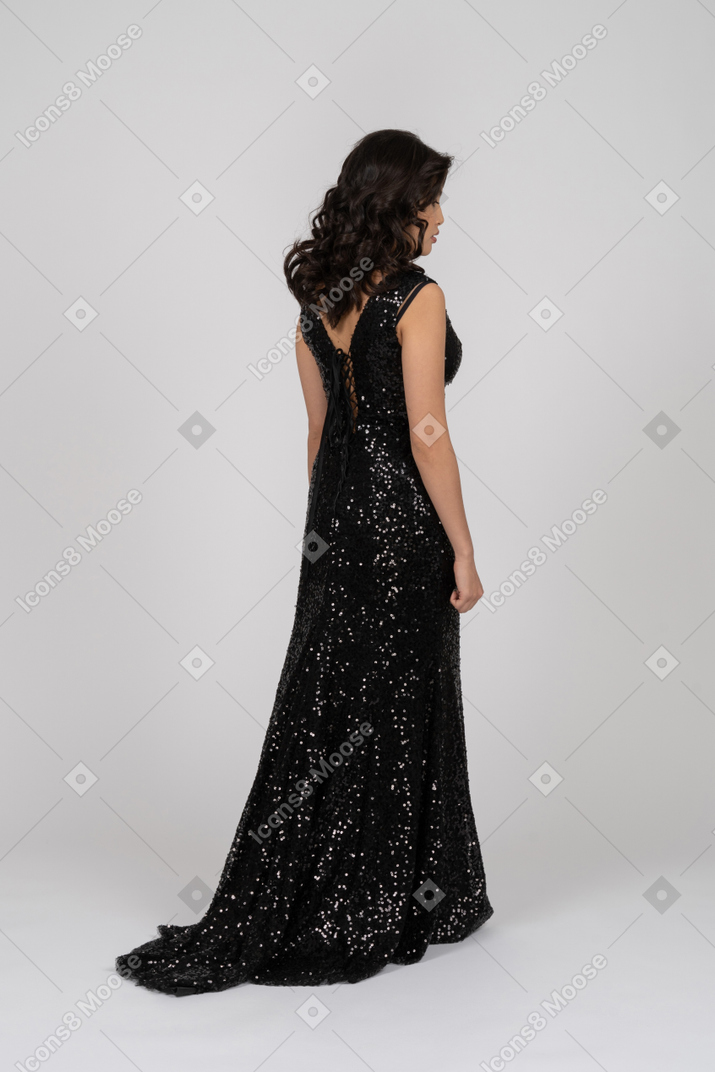 Femme réfléchie portant une robe de soirée noire
