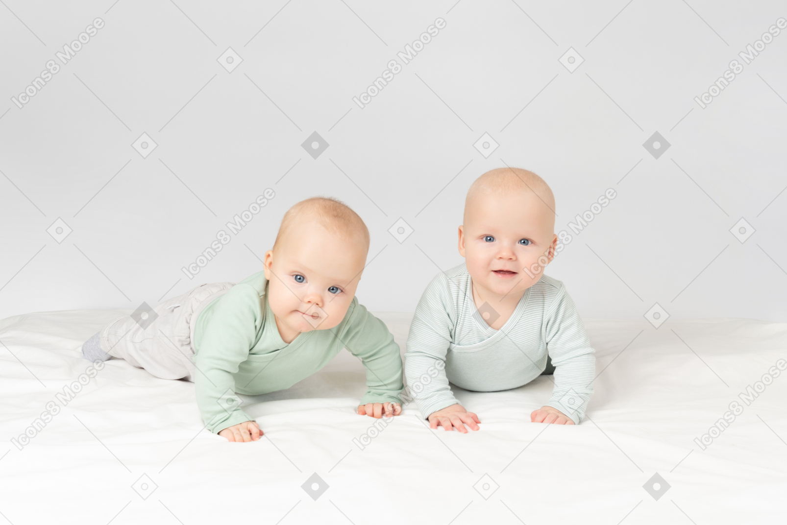 Curious babies twins lying on the stomach