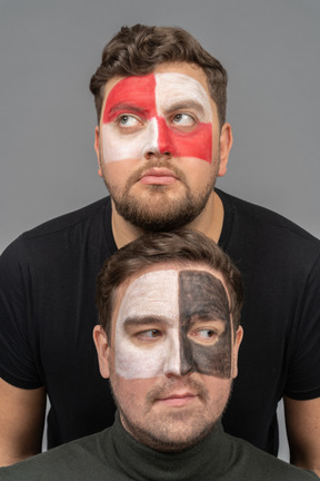 Front view of two male football fans with face art