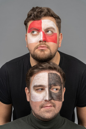 Vue de face de deux fans de football masculins avec l'art du visage