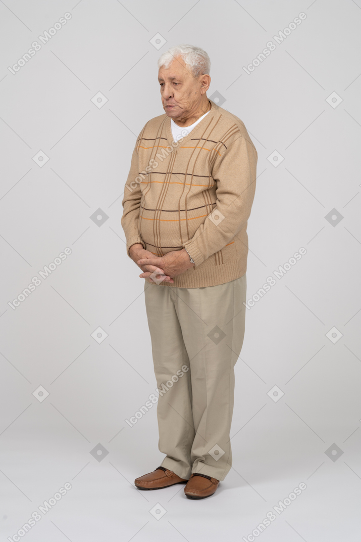 Front view of an old man in casual clothes making faces