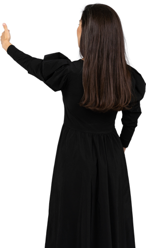 一位年轻的女士，穿着一件黑色的连衣裙，现身拇指的后视图