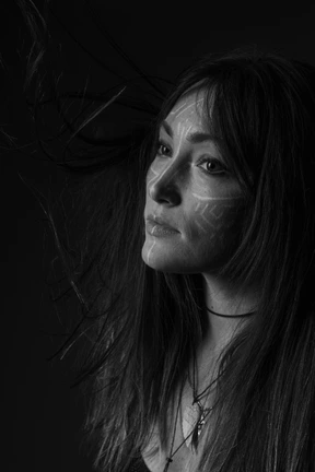 Black and white photo of woman with tribal face paint