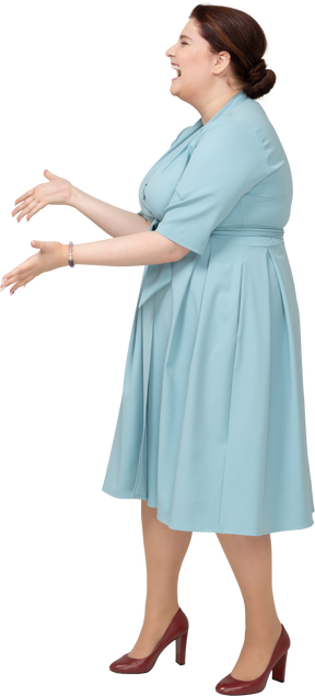 Vista laterale di una donna felice in abito blu che gesticola
