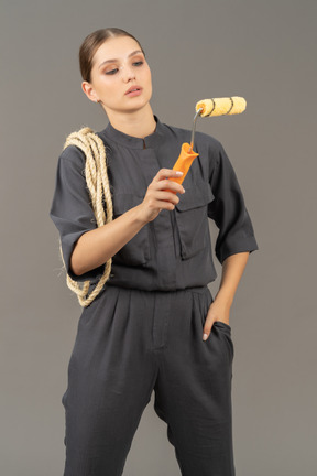 Woman in gray coveralls using a paint roller