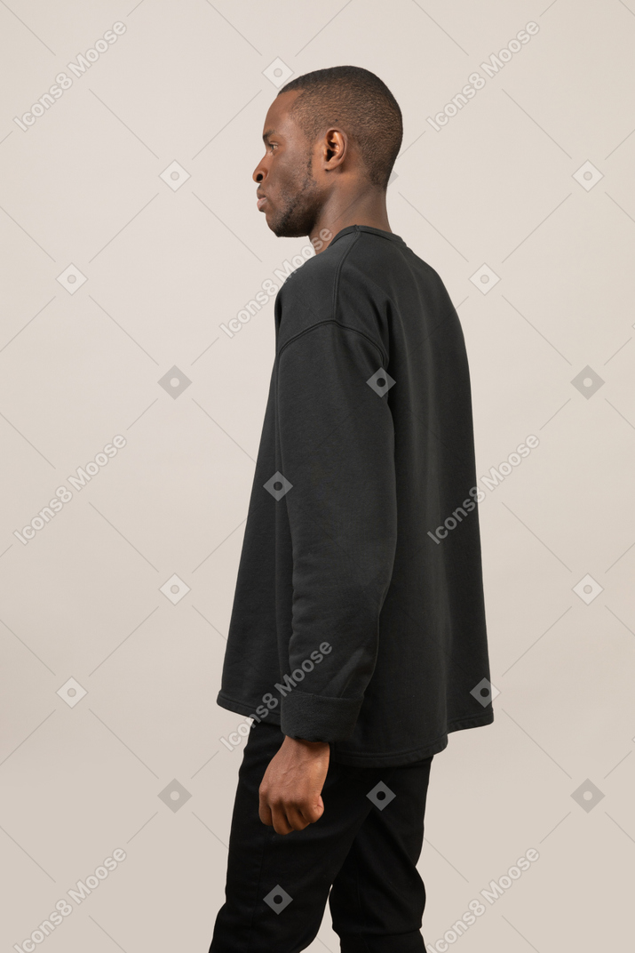 Side view of young man in black casual clothing