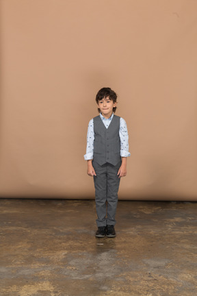 Front view of a boy in suit standing still and looking at camera