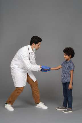 Pequeno paciente e médico apertando as mãos