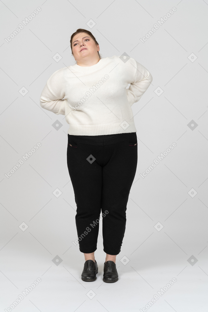 Plus size woman in casual clothes suffering from pain in lower back