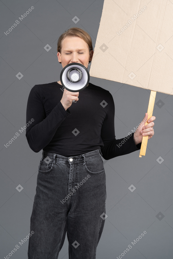 Person shouting with megaphone and sign in hand