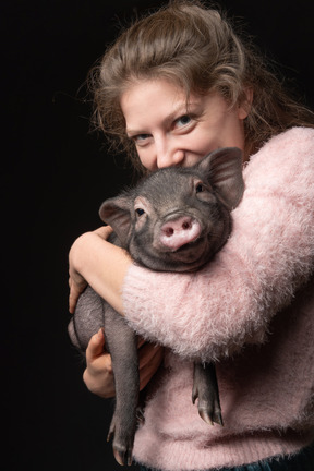 Hermosa chica con cerdo en miniatura