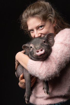 Beautiful girl holding miniature pig