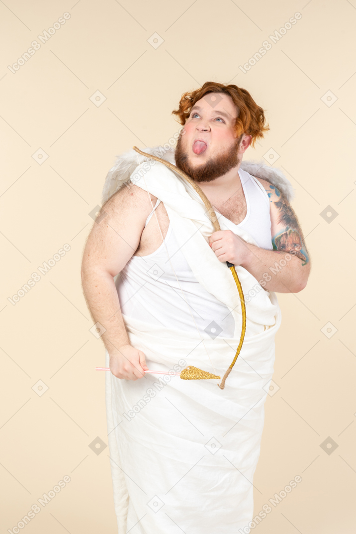Big guy dressed as a cupid sticking out a tongue