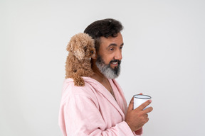 Hombre tomando un café mientras su linda mascota sentada sobre su hombro