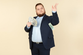 A plus-size man in a black costume with dollar bills in his hands