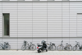 Vélos et scooter garés devant le bâtiment