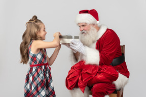 Niña niño abriendo un regalo que santa le trajo