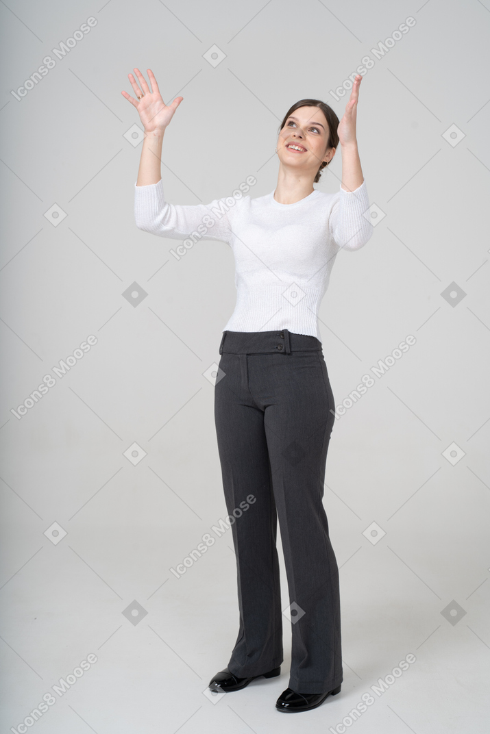 Vista frontal de una mujer en traje mirando hacia arriba y gesticulando