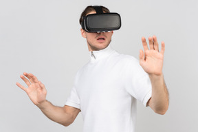 Man in virtual reality headset standing with his hands raised