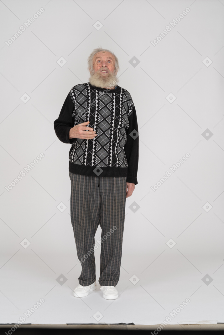 Old man standing and looking up with raised hand
