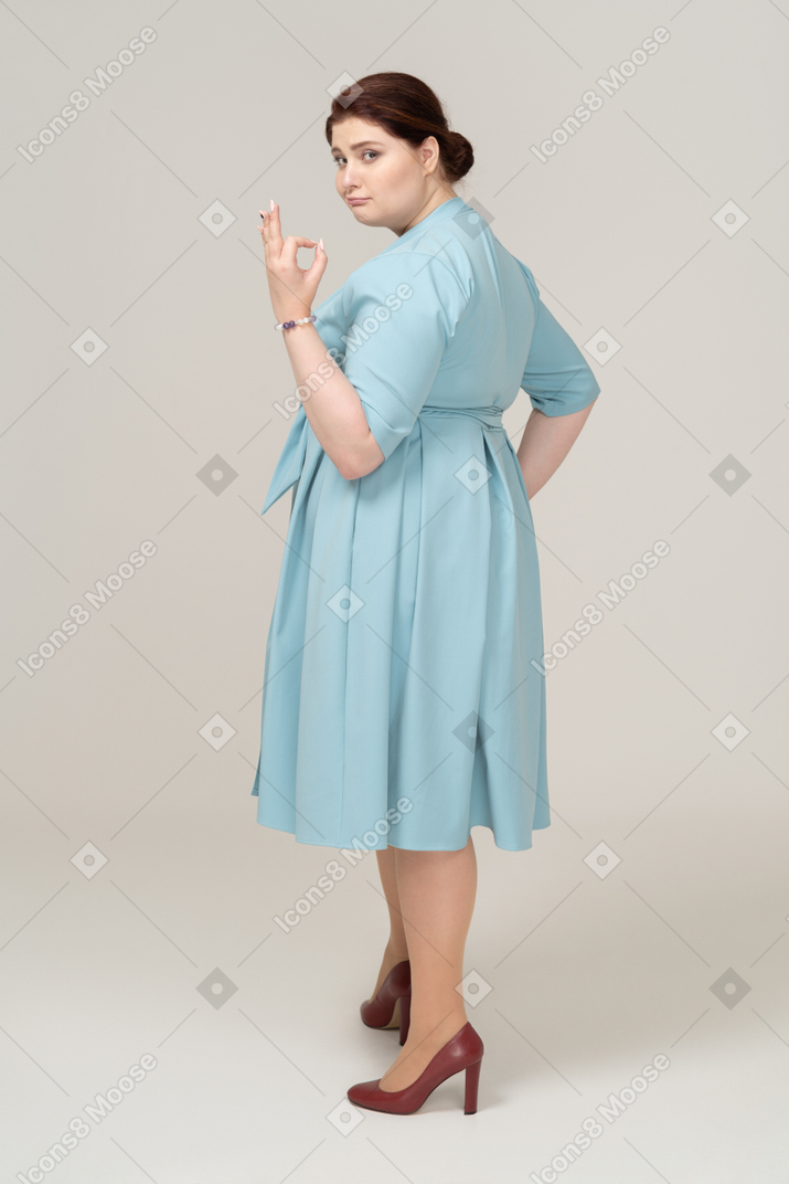 Vista lateral, de, un, mujer, en, vestido azul, actuación, señal ok