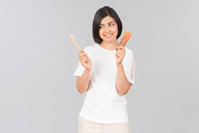 Young indian woman holding toothpaste and toothbrush