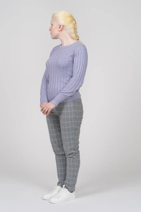 Three-quarter view of a young woman with folded hands looking left