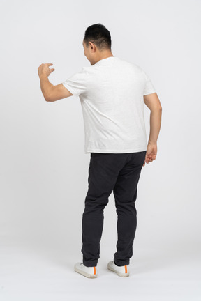 Rear view of a man in casual clothes showing size of something