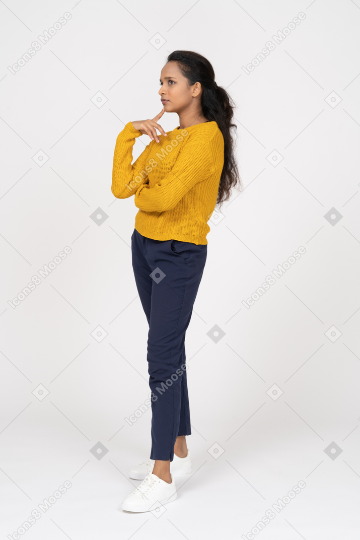Side view of a thoughtful girl in casual clothes touching chin with fingers