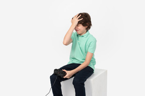 Мальчик-геймер в отчаянии хлопает себя по голове