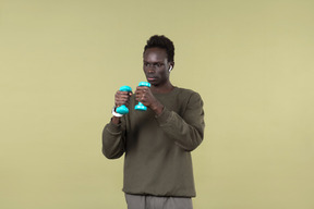 Young black man wearing casual clothes, with airpods and smartwatch on in the process of his workout