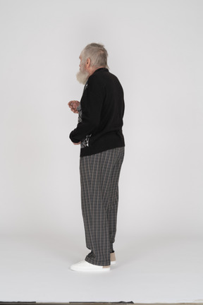 Side view of old man standing and gesturing