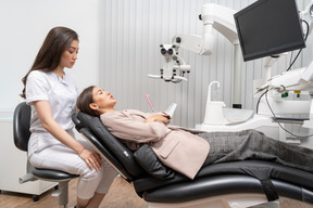 Front view female dentist talking to her naughty patient in a hospital cabinet