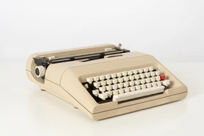 Beige typewriter on a white background