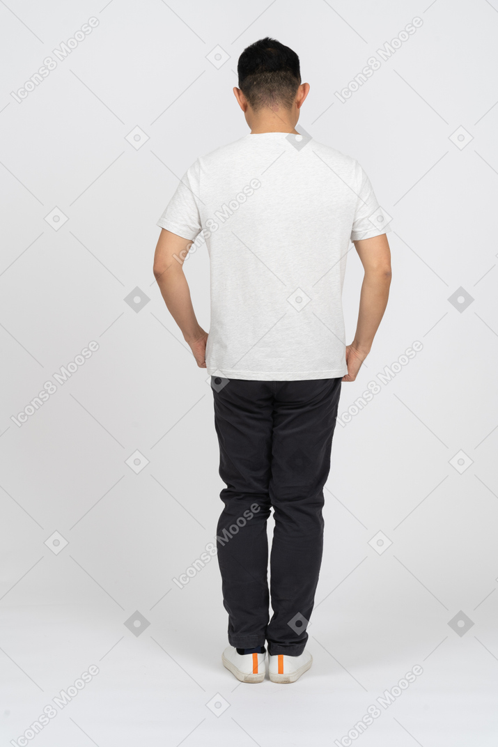 Мужчина в повседневной одежде стоит спиной к камере