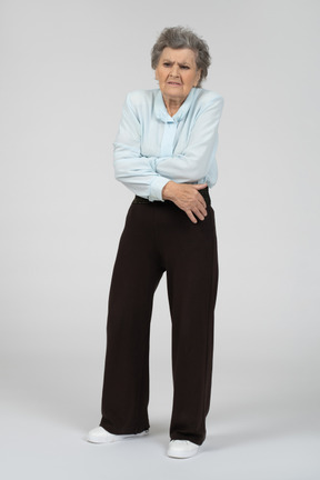Front view of elderly woman hugging herself