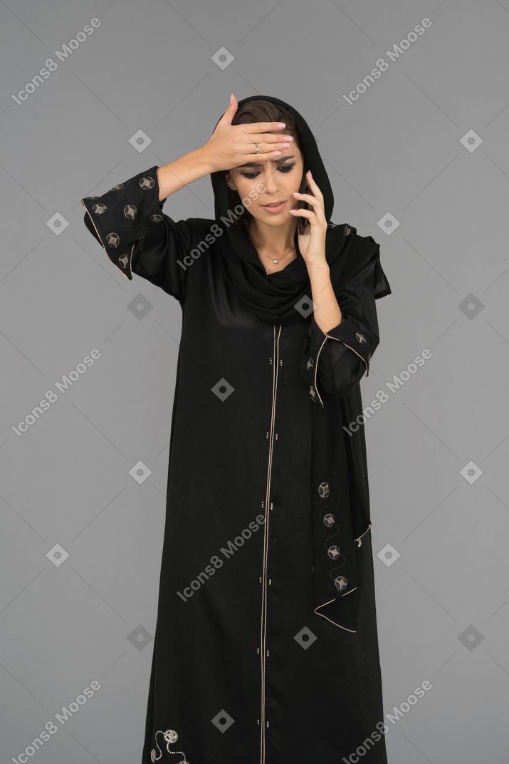 Uma mulher árabe deprimida, falando ao telefone