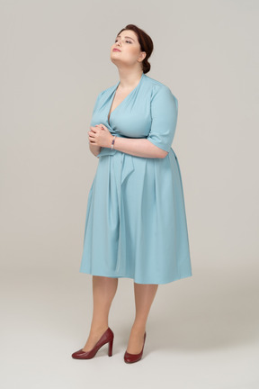 Vista lateral de uma mulher de vestido azul posando