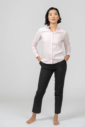 Woman in office clothes standing with hands on hips