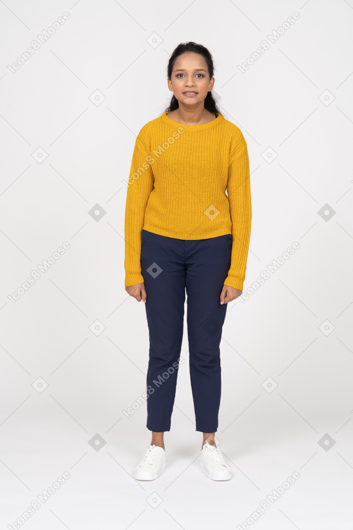 Front view of a happy girl in casual clothes looking at camera