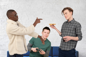 Friends hanging out, eating pizza and gaming