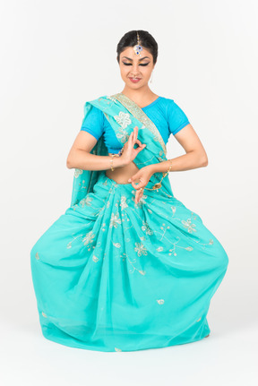 Jeune femme indienne en sari bleu debout en position de danse