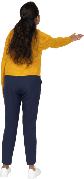Rear view of a girl in casual clothes showing direction